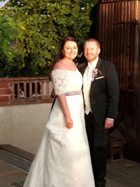 Melanie und Andreas im Hochzeitsgewand vor einer Tschardarke.