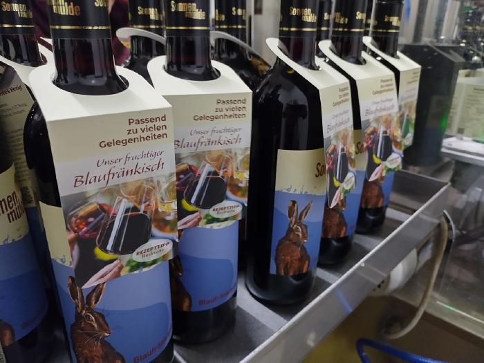 Blaufränkisch Flaschen beim Etikettieren. Die Schleifen mit dem Rezept wurden am Flaschenhals befestigt.