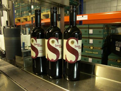 A few freshly labelled bottles on the table of the labeling machine.